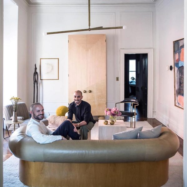 Os simpáticos Gabriel Hendifar e Jeremy Anderson posam no living de seu apartamento em Nova York.