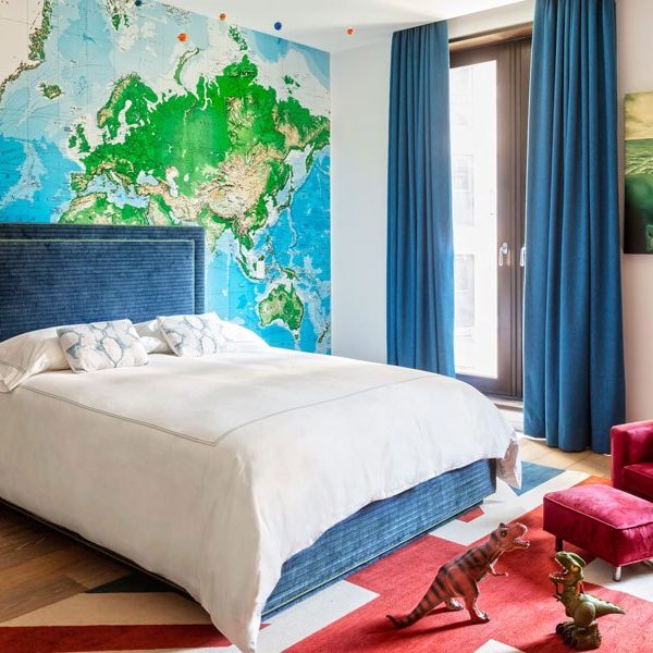 O azul predomina no quarto do filho de Laura, que recebeu tapete com desenho da bandeira inglesa, e mapa múndi forrando toda a parede da cabeceira da cama.