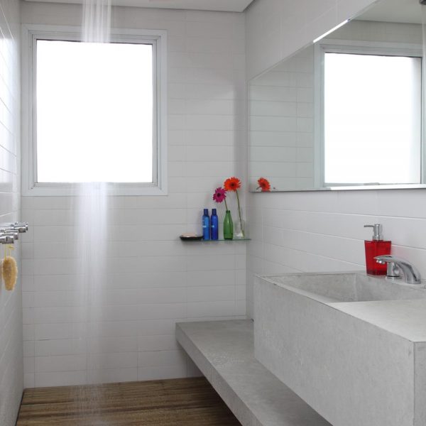 Linhas puras e simples fazem o espaço parecer maior, anote! O banheiro, que recebeu piso/deck em madeira ficou funcional e bacana.