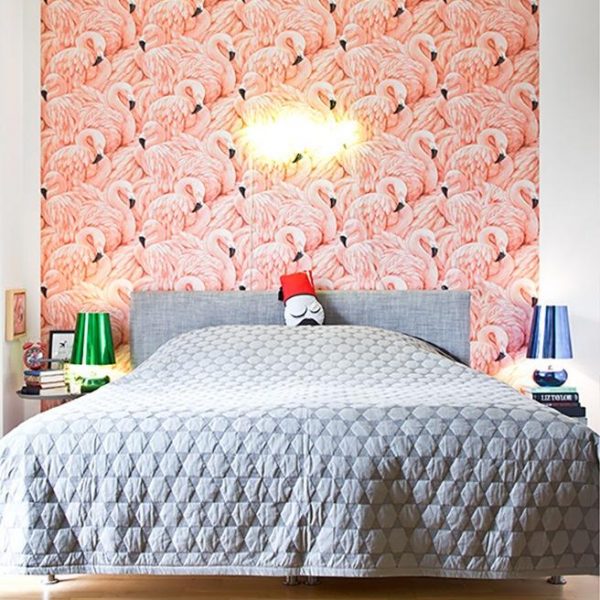 O papel de parede super bacana de flamingos, é acompanhado por colcha cinza, o que equilibra a composição! Adorei.
