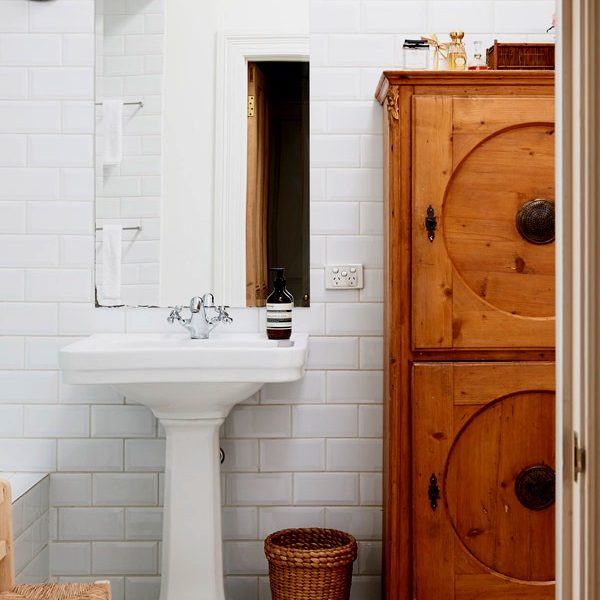 Banheiro com estilo bem americano recebe armário em madeira.