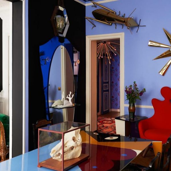Mesa gráfica, sofá inspirado em Salvador Dalí em forma de silhuetas humanas, estrela de metal anos 1960, insetos cujos olhos se iluminam e um espelho de vidro azul. Mais Dalí impossível.
