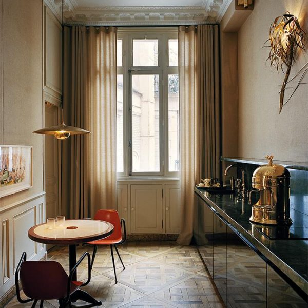 A cozinha, com luminárias Florian Schulz, é usada quase que exclusivamente para o café da manhã. Paredes revestidas de juta, mármore verde na bancada e mesa desenhada pelos proprietários. Tudo lindo e super chique.