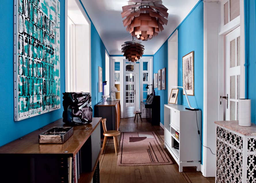 Paredes em azul forte, chamado na Europa de azul da Prússia, recobre as paredes e faz par perfeito com a mobília vintage. Luminárias de Louis Poulsen
