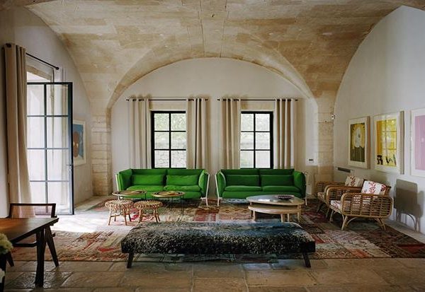 Os sofás verdes fazem interlocução perfeita com as características originais do imóvel.