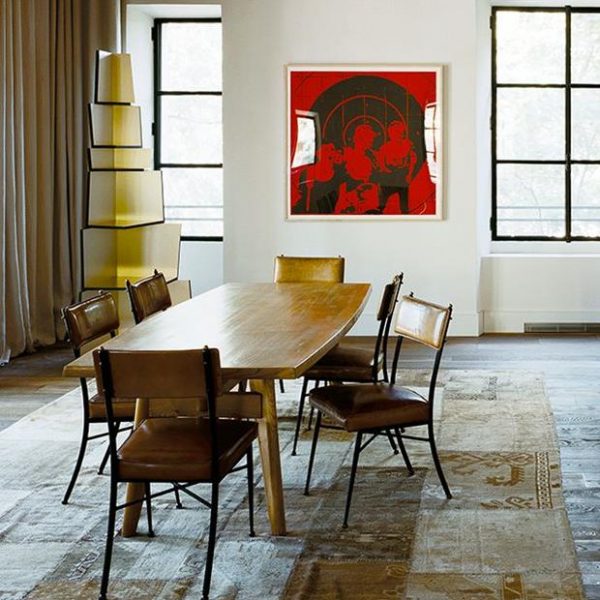 Conjunto de mesa e cadeiras de época sobre tapete de retalhos persa contrastam com obras de arte contemporâneas.