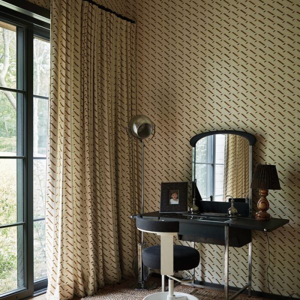 Uma penteadeira e uma cadeira francesa vintage refletem a luz em um dos quartos de hospedes de Muriel Brandolini em Long Island